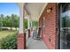 Inviting covered front porch with classic rocking chairs and brick pillars showcasing a relaxed outdoor space at 100 Coldwater Creek Dr, Mcdonough, GA 30252