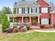 Charming brick home featuring a cozy front porch with white railings and a well-maintained lawn at 100 Coldwater Creek Dr, Mcdonough, GA 30252