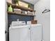 Laundry room with modern washer and dryer, floating shelves, and stylish decor at 100 Coldwater Creek Dr, Mcdonough, GA 30252