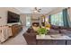Cozy living room featuring a brick fireplace, plush sectional, and large TV, perfect for relaxation at 100 Coldwater Creek Dr, Mcdonough, GA 30252