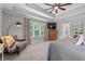 Well-appointed main bedroom with tray ceiling, large windows, and comfortable seating area at 100 Coldwater Creek Dr, Mcdonough, GA 30252