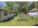 Large, grassy backyard featuring an outbuilding, garden, and treeline at 1001 Rhett Nw Dr, Kennesaw, GA 30144