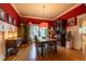 Elegant dining room featuring a large wooden table, bright red walls and unique decor at 414 Pensdale Rd, Decatur, GA 30030