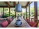 View of the screened porch featuring a wooden table and chairs, pendant lights, and lots of greenery at 414 Pensdale Rd, Decatur, GA 30030