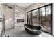 Bathroom with modern black tub next to a fireplace and glass door overlooking the outdoor deck at 4366 Skyland Ne Dr, Atlanta, GA 30342