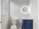 Bathroom features modern lighting, stylish blue vanity, and patterned accent wall at 4366 Skyland Ne Dr, Atlanta, GA 30342