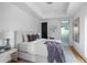 Bright bedroom with tray ceilings, white walls, plush bed, side table, and frosted sliding door at 4366 Skyland Ne Dr, Atlanta, GA 30342