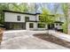 Modern home featuring a black framed glass garage door, white siding, and a curved concrete driveway at 4366 Skyland Ne Dr, Atlanta, GA 30342