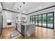 Modern kitchen featuring a large island with marble countertop, stainless steel appliances, and black window frames at 4366 Skyland Ne Dr, Atlanta, GA 30342