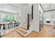Bright, open-concept living space featuring hardwood floors, large windows, and a modern staircase at 4366 Skyland Ne Dr, Atlanta, GA 30342
