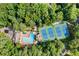 Aerial view of a community pool and tennis courts surrounded by mature trees and lush landscaping at 5040 Winding Branch Dr, Dunwoody, GA 30338