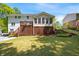 View of backyard featuring a spacious lawn, deck, and lattice-enclosed area at 5040 Winding Branch Dr, Dunwoody, GA 30338