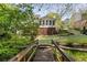 Back exterior featuring a lushly landscaped yard and covered porch at 5040 Winding Branch Dr, Dunwoody, GA 30338