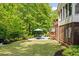 Spacious backyard with a stone patio, dining set, and manicured lawn at 5040 Winding Branch Dr, Dunwoody, GA 30338