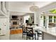 Bright dining room with modern lighting and backyard views leading to living room at 5040 Winding Branch Dr, Dunwoody, GA 30338