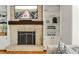 Living room fireplace with TV, decor, and built-in shelves at 5040 Winding Branch Dr, Dunwoody, GA 30338