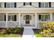 Inviting front porch featuring white railings, columns, and decorative plants at 5040 Winding Branch Dr, Dunwoody, GA 30338