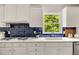 Stylish kitchen with white cabinets, blue tile backsplash, and a modern sink at 5040 Winding Branch Dr, Dunwoody, GA 30338