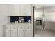 Kitchen features white cabinetry, stainless steel refrigerator, and blue backsplash at 5040 Winding Branch Dr, Dunwoody, GA 30338