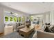 Open-concept living room featuring hardwood floors and seamless transitions to a bright sunroom at 5040 Winding Branch Dr, Dunwoody, GA 30338