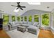 Bright sunroom with skylights, large windows and a sectional sofa with ottomans at 5040 Winding Branch Dr, Dunwoody, GA 30338