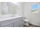 Bathroom with white cabinets, vanity, mirror and sink, plus a toilet at 881 Springs Crest Dr, Dallas, GA 30157