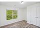 Bedroom with wood-look floors, double door closet, and a window with a green view at 881 Springs Crest Dr, Dallas, GA 30157