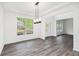 Dining room with hardwood floors, modern light fixture, and large windows overlooking backyard at 881 Springs Crest Dr, Dallas, GA 30157