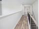 The second floor hallway has wood-look floors, trim, and black metal railings at 881 Springs Crest Dr, Dallas, GA 30157