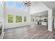 Bright, open living room boasts high ceilings, fireplace, modern ceiling fan, and view of wooded yard at 881 Springs Crest Dr, Dallas, GA 30157
