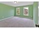 This bedroom features green walls, gray carpet, and double hung windows at 900 Fox Croft Pl, Canton, GA 30114