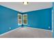 This bedroom features blue walls, gray carpet, and a corner double hung window at 900 Fox Croft Pl, Canton, GA 30114