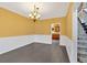 Formal dining room with wainscoting, dark hardwood floors, and elegant lighting at 900 Fox Croft Pl, Canton, GA 30114