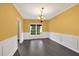 Formal dining room with wainscoting, dark hardwood floors, and elegant lighting at 900 Fox Croft Pl, Canton, GA 30114