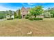 Large brick home with green lawn and trees at 900 Fox Croft Pl, Canton, GA 30114