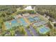 Aerial view of the community tennis courts, with a clubhouse, parking, and surrounding trees at 900 Fox Croft Pl, Canton, GA 30114