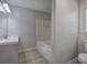 Bathroom with single sink vanity, bathtub, toilet, and wood-look vinyl floor at 2528 Mulberry Rock Rd, Dallas, GA 30157