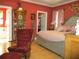 This bedroom features a red accent wall and a large, tufted headboard, plus beautiful hardwood floors at 28 County Line #2 Rd, Rydal, GA 30171