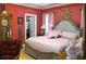 Cozy bedroom featuring a tufted headboard, red walls, and a view into the walk-in closet at 28 County Line #2 Rd, Rydal, GA 30171