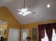 A vaulted ceiling with a ceiling fan above a room with orange walls and white trim on doors and windows at 28 County Line #2 Rd, Rydal, GA 30171