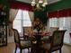 Elegant dining area featuring a chandelier, a round glass-top table, and bright light from a window at 28 County Line #2 Rd, Rydal, GA 30171
