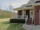 Inviting brick home featuring a covered porch, manicured lawn, and well-maintained landscaping at 28 County Line #2 Rd, Rydal, GA 30171