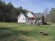 Exterior view of a home featuring a large backyard and a covered deck at 28 County Line #2 Rd, Rydal, GA 30171