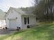 Exterior view of the detached garage, featuring clean white siding, black shutters, and a concrete driveway at 28 County Line #2 Rd, Rydal, GA 30171