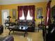 Inviting living room with plush leather furniture, wood floors, and natural light through red-curtained windows at 28 County Line #2 Rd, Rydal, GA 30171