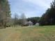 Large front yard with mature trees and long driveway at 28 County Line #2 Rd, Rydal, GA 30171