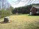 Expansive yard with mature trees, a large boulder, and landscaping at 28 County Line #2 Rd, Rydal, GA 30171