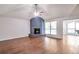 Spacious living room with hardwood floors, a painted brick fireplace, ceiling fan, and large windows at 814 Arbor Hill Dr, Stone Mountain, GA 30088