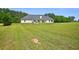 View of a large grassy backyard with a single-Gathering home in the background at 330 Pitts Chapel Rd, Newborn, GA 30056