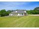 View of the house and a large fenced-in grassy backyard with mature trees in background at 330 Pitts Chapel Rd, Newborn, GA 30056